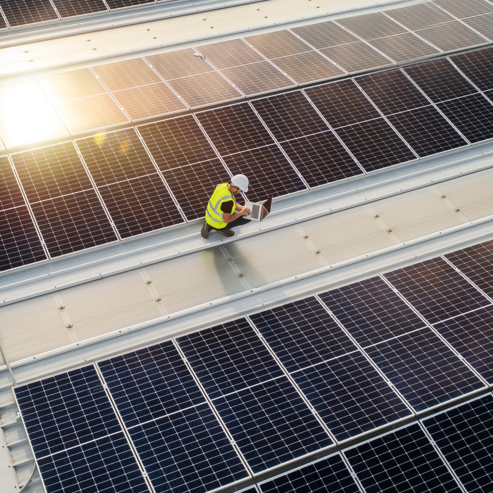 Commercial Solar Panels On A Roof With A Man Working